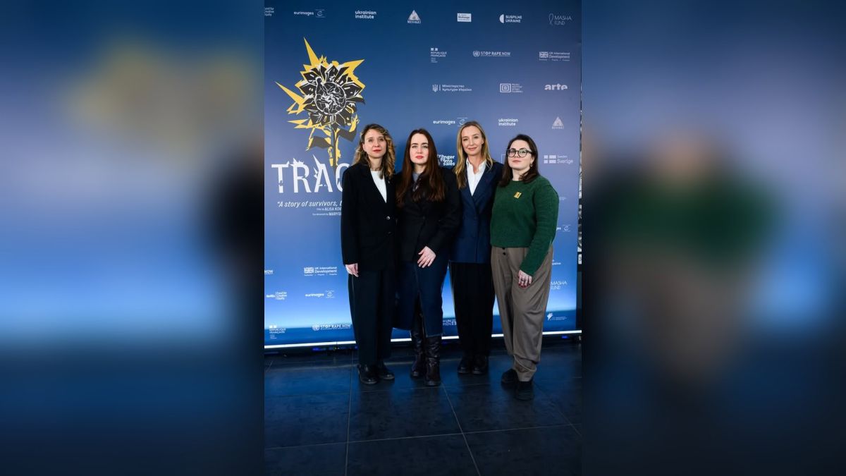 Учасниці закритого показу документального фільму «Сліди» у Києві на фоні банера з назвою стрічки та логотипами партнерів
