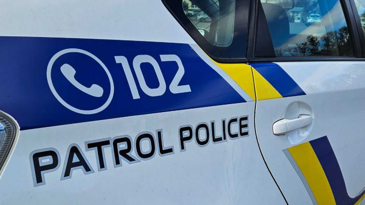 Службовий автомобіль патрульної поліції України білого кольору з написом Patrol Police на дорозі