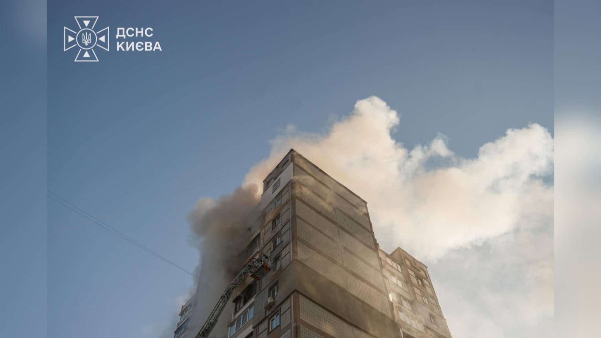 Дим над багатоповерхівкою на вулиці Градинській у Деснянському р-ні Києва під час пожежі, рятувальники працюють з автодрабини