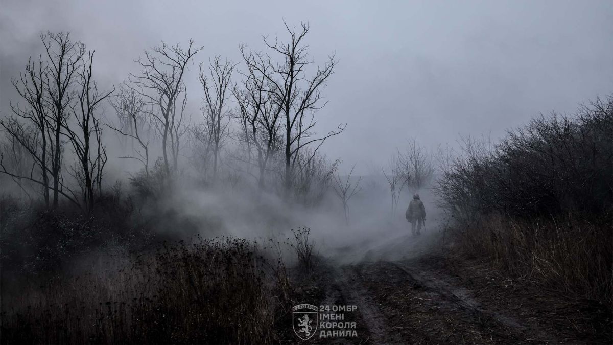 Український боєць йде земляною дорогою в тумані