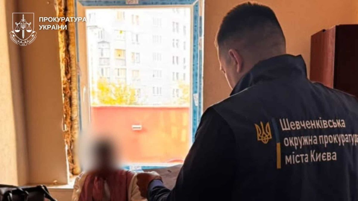 Пацієнт пережив клінічну смерть: анестезіологині повідомили про підозру Працівник Шевченківської окружної прокуратури Києва вручає документи жінці з розмитим обличчям за столом у кабінеті