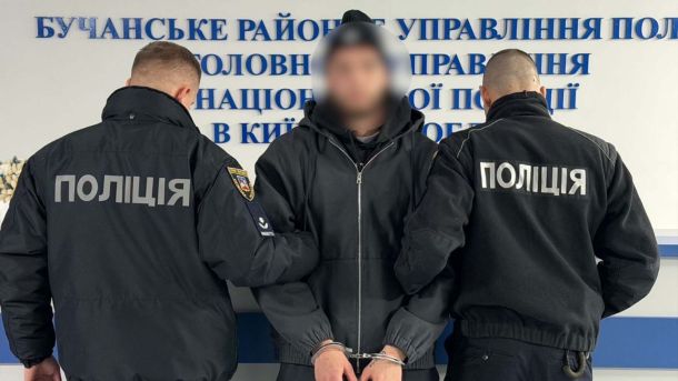 У Києві затримали чотирьох наркоділків із канабісом на пів мільйона гривень Двоє поліцейських у формі конвоюють затриманого в наручниках у Бучанському районному управлінні поліції на Київщині