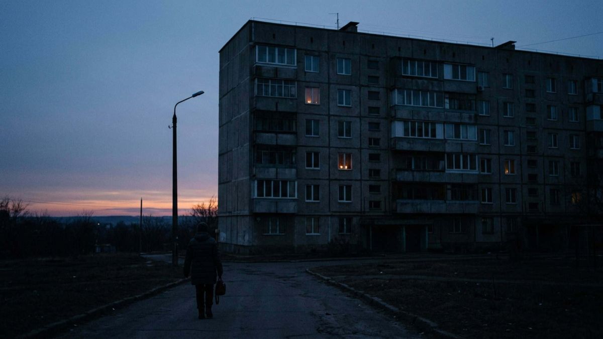 Атаки на енергоінфраструктуру: аварійні відключення у Києві й на Київщині Житловий будинок у сутінках без світла, лише кілька вікон освітлені свічками