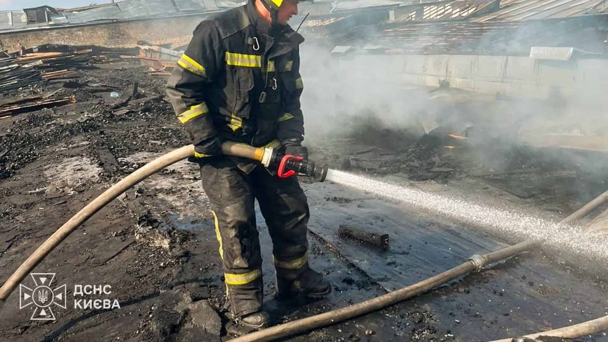 Атака на Київ: загинула жінка, 26 поранених у чотирьох районах (оновлено) Рятувальник ДСНС у захисному спорядженні спрямовує струмінь води на згарище після нічної атаки на Київ 5 серпня
