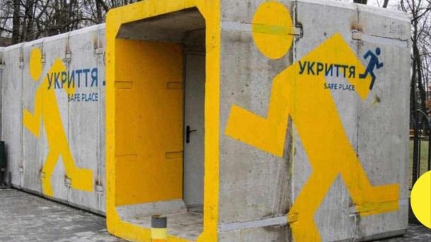 Мобільне укриття, сіра бетонна одноповерхова споруда із намальованими жовтими силуетами людей