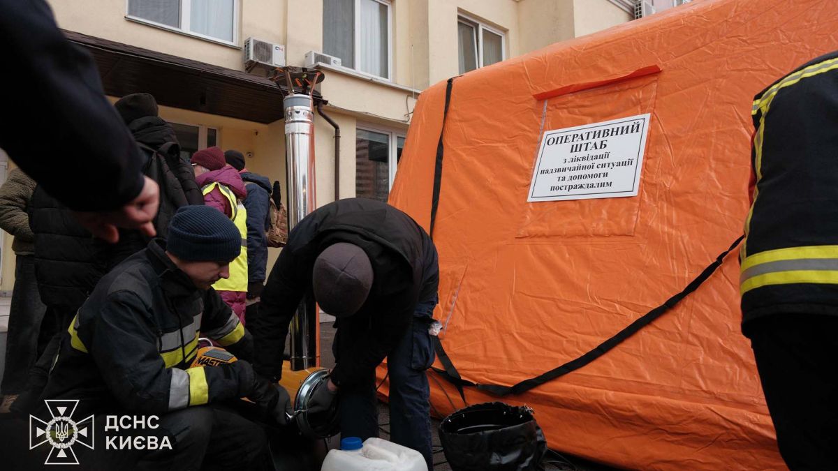 Рятувальні роботи у трьох районах Києва: де шукати допомогу Намет з написом Оперативний штаб з ліквідації надзвичайної ситуації та допомоги постраждалим, біля нього группа людей серед яких рятувальники