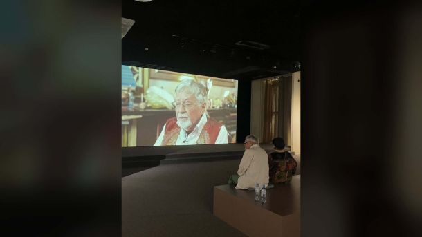 Відвідувачі дивляться відео з Олександром Дубовиком на виставці лабіринти значень в Українському домі