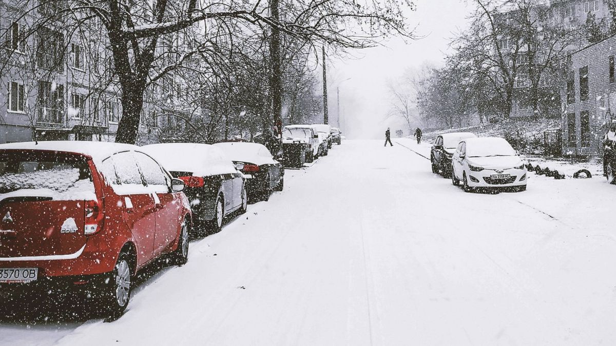 Припарковані автомобілі та дорога у снігу