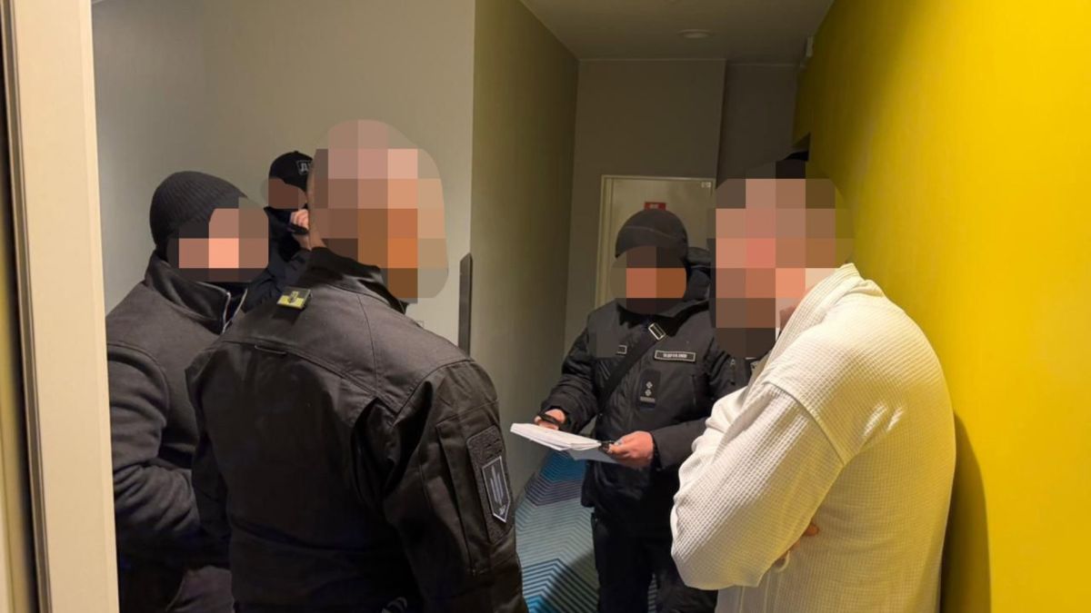 Працівники ДБР зачитують підозрюваному документ