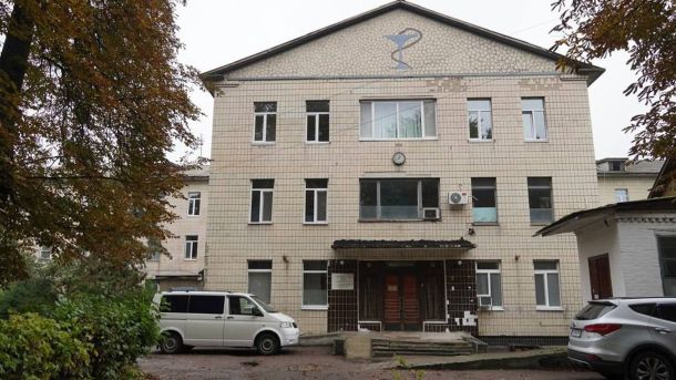 Триповерхова будівля Фастівської лікарні у київській області, біля входу стоять два автомобілі