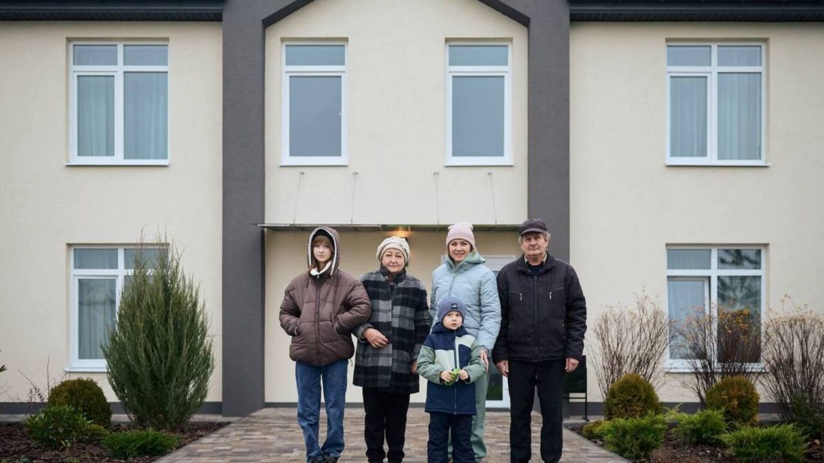 Переселенці біля нового будинку