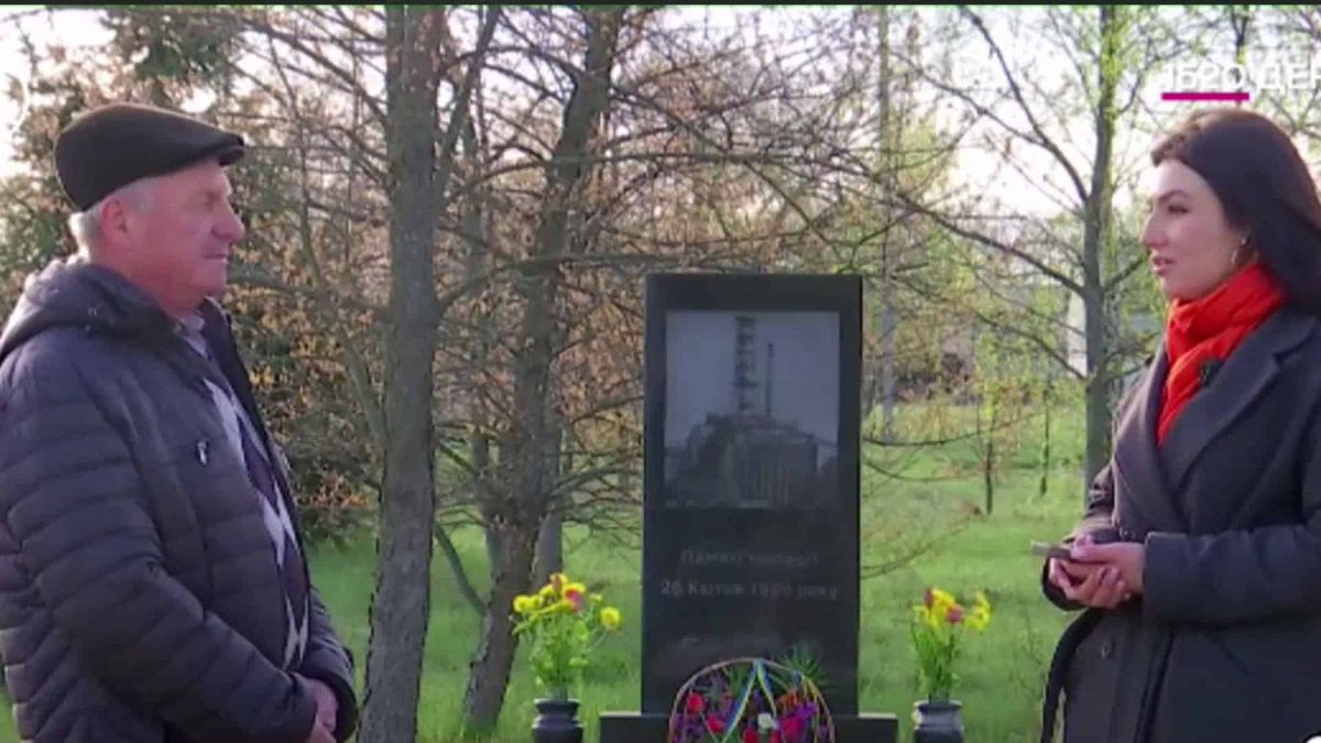 Ліквідатор аварії на ЧАЕС Олексій Заяць розмовляє з журналісткою біля меморіалу жертвам Чорнобильської трагедії — кадр із сюжету Kyiv24 до 40-річчя катастрофи