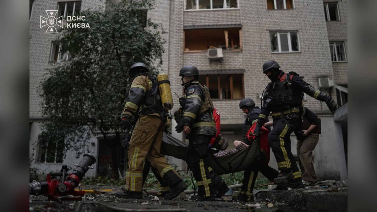 Рятувальники ДСНС виносять на ношах постраждалу від пошкодженого атакою будинку у Печерському р-ні Києва