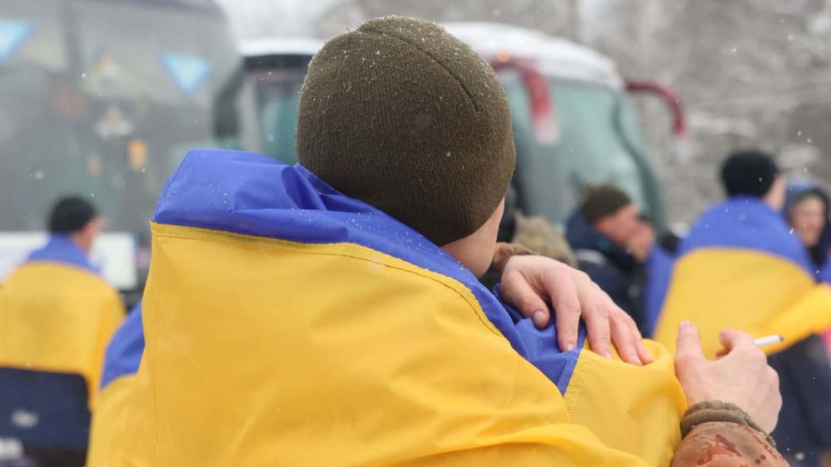 Звільнені з полону захисники України та їхні родичі біля автобусу
