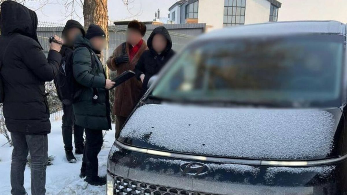 Правоохоронці та підозрювана особа біля автомобіля