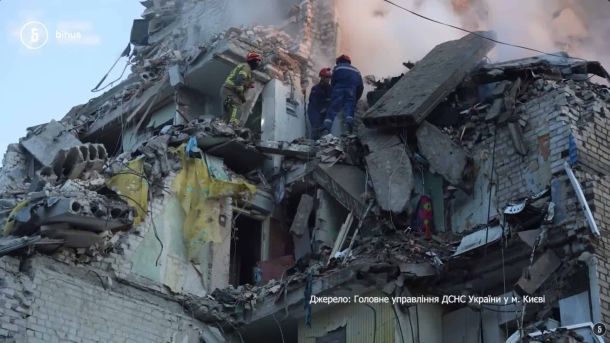 Рятувальники ДСНС розбирають завали верхніх поверхів зруйнованої російським ударом багатоповерхівки в Києві
