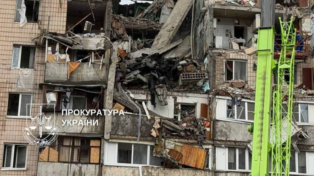 Повністю зруйновані поверхи під'їзду багатоповерхівки внаслідок ракетного удару, працює будівельний кран