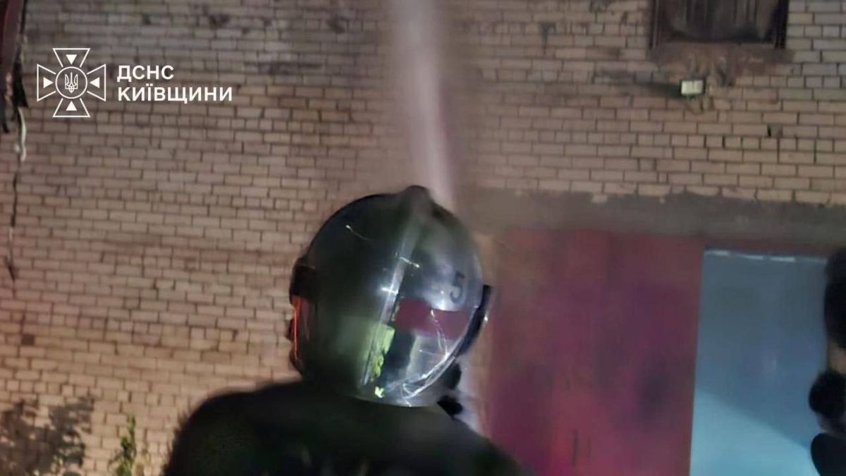 Працівник «Київтеплоенерго» загинув у Солом’янському р-ні (оновлено) Рятувальник ДСНС Київщини у захисному спорядженні спрямовує струмінь води у вікно пошкодженої цегляної будівлі