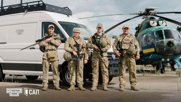 Збройні сили України на фоні військової техніки і гелікоптера під час виконання бойового завдання у Києві.