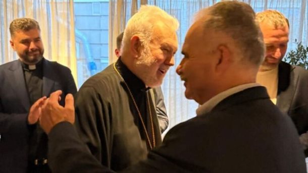 Група чоловіків вітається у приміщенні