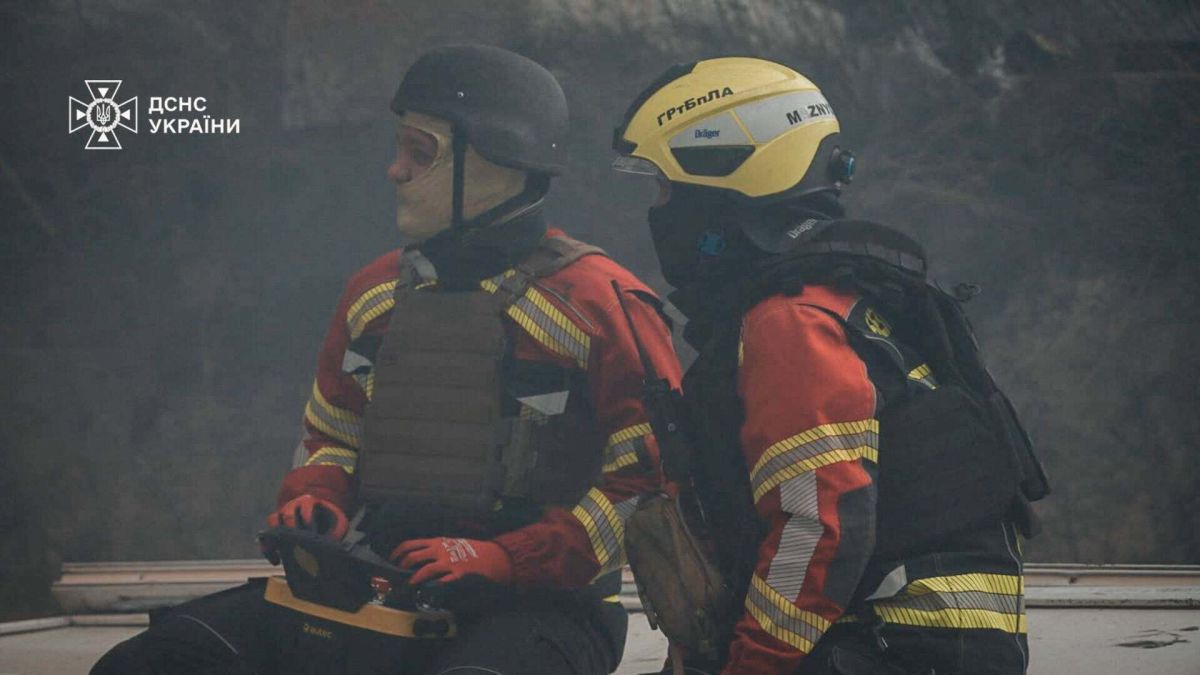 У Шевченківському районі БпЛА влучив у 6-поверховий будинок — пожежа Двоє рятувальників ДСНС у щільному димі, один тримає пульт керування розвідувальним безпілотником