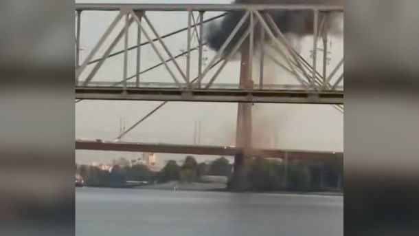 Чорний дим біля пілона Північного мосту в Києві після влучання 3 жовтня, вигляд крізь ферми сусіднього мосту з боку Дніпра