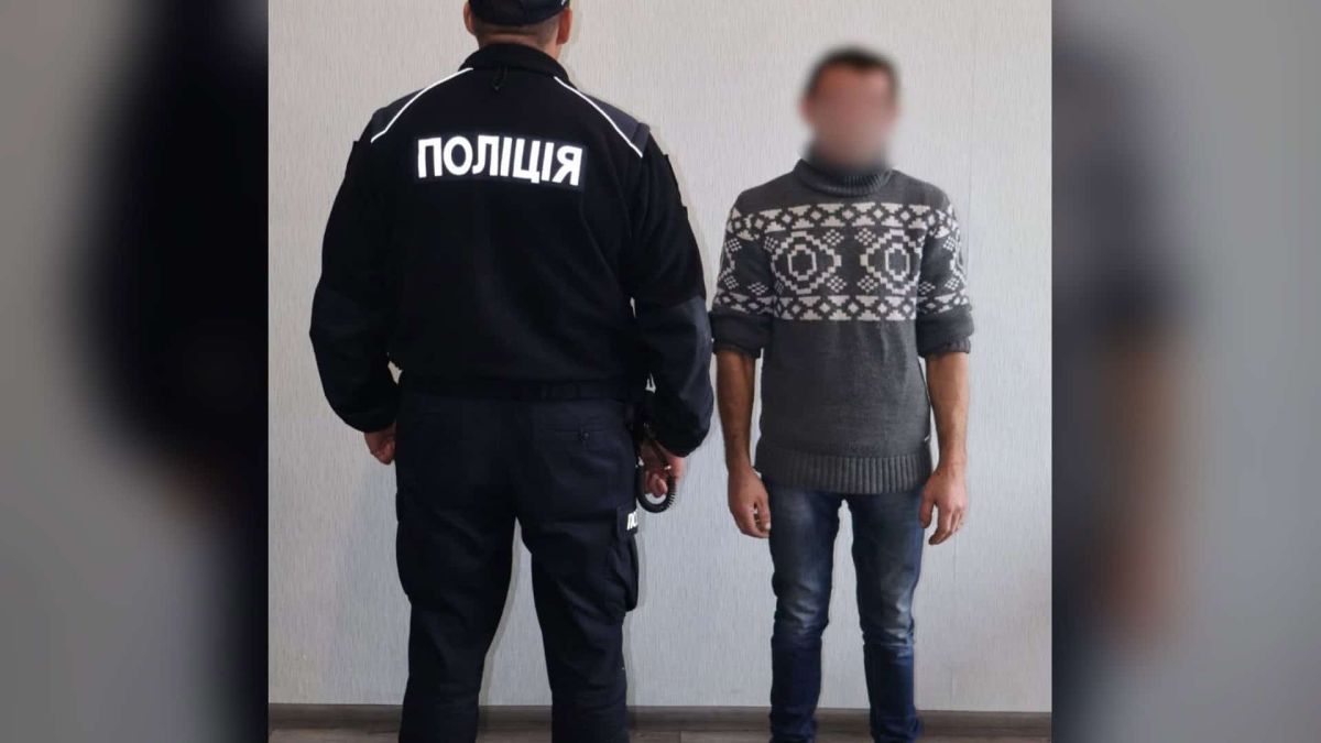 Поліцейський у формі поруч із 37-річним чоловіком, якому на Бориспільщині повідомили про підозру в катуванні пасинка