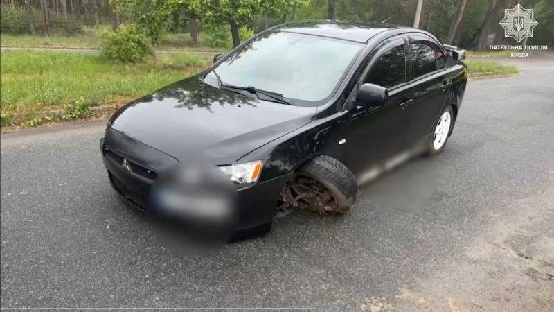 Головні новини Києва | Kyiv.News Чорний Mitsubishi Lancer з пошкодженим колесом після ДТП у Голосієвому районі Києва