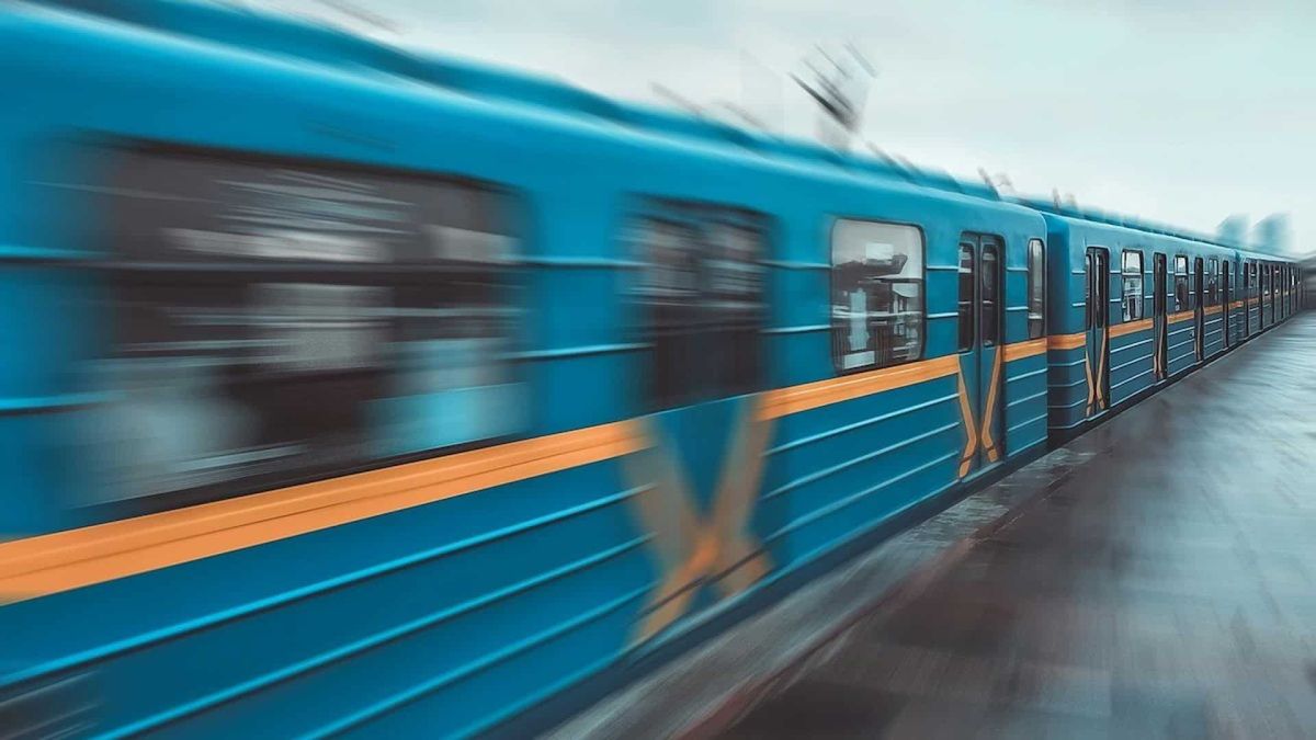 Синій вагон київського метро з помаранчевою смугою рухається вздовж платформи — ілюстрація до новини про закупівлю 224 нових вагонів
