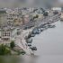 Головні новини Києва | Kyiv.News Логотип уряду України на тлі офісного будинку — Київ і Київщину додано до зон підвищеного ризику, компенсації для бізнесу зросли до 5 млн грн
