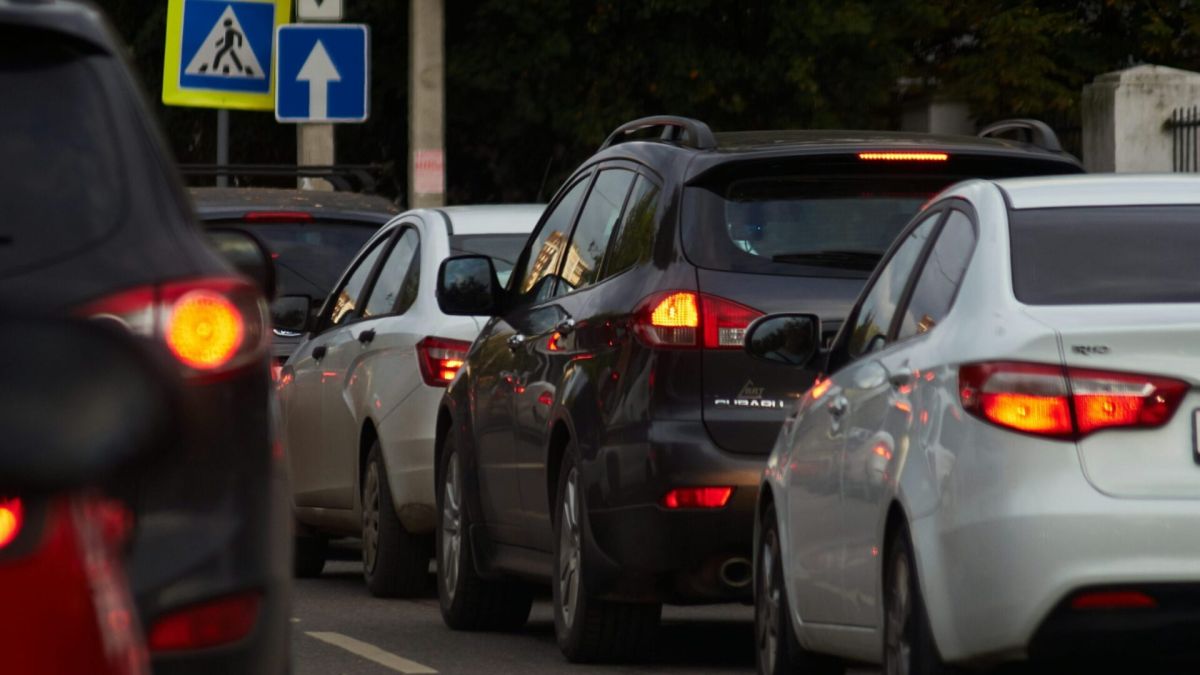 Автомобільний затор на міській дорозі з увімкненими стоп-сигналами та дорожніми знаками