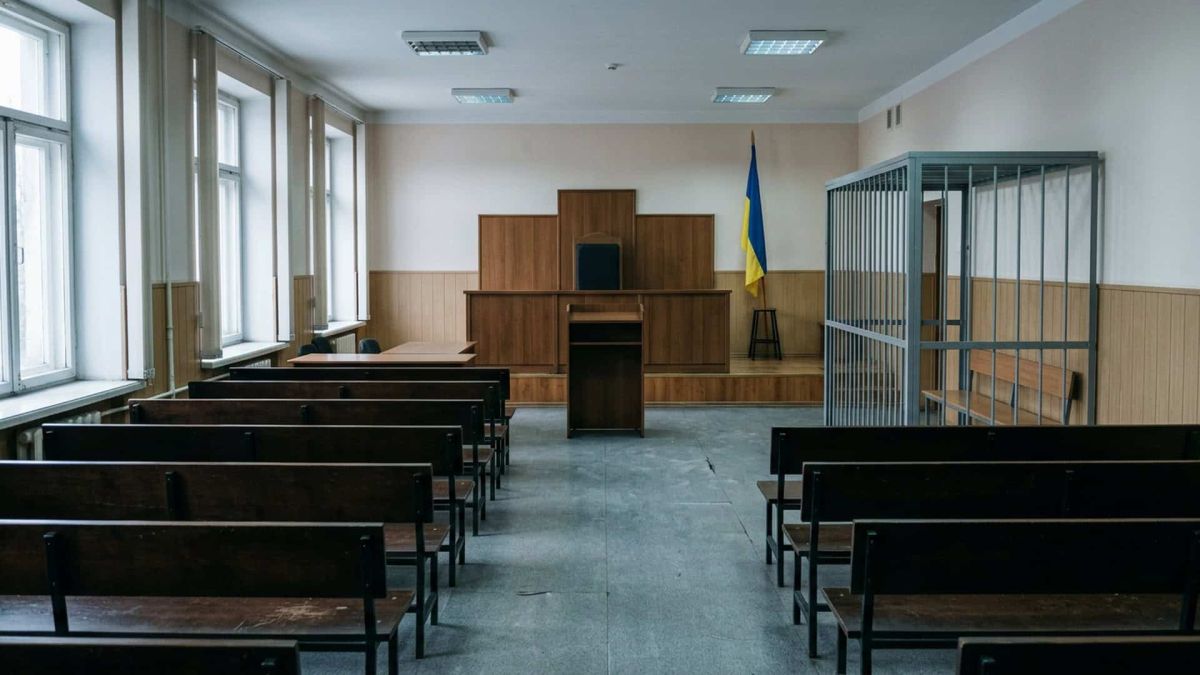 Порожній зал судових засідань з місцем судді та лавами для присутніх