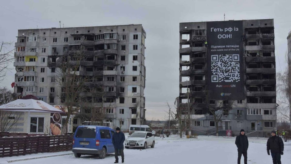 Великий банер на пошкоджені війною багатоповерхівці із закликом пілписати петицію щодо виключення РФ з ООН