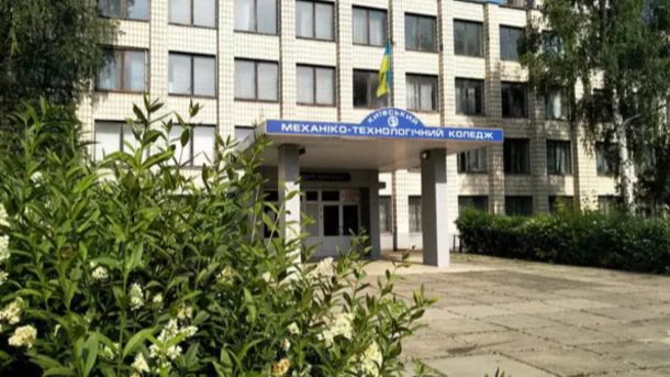 Будівля Київського механіко-технологічного фахового коледжу з вивіскою на фасаді, зелені кущі та дерева навколо входу