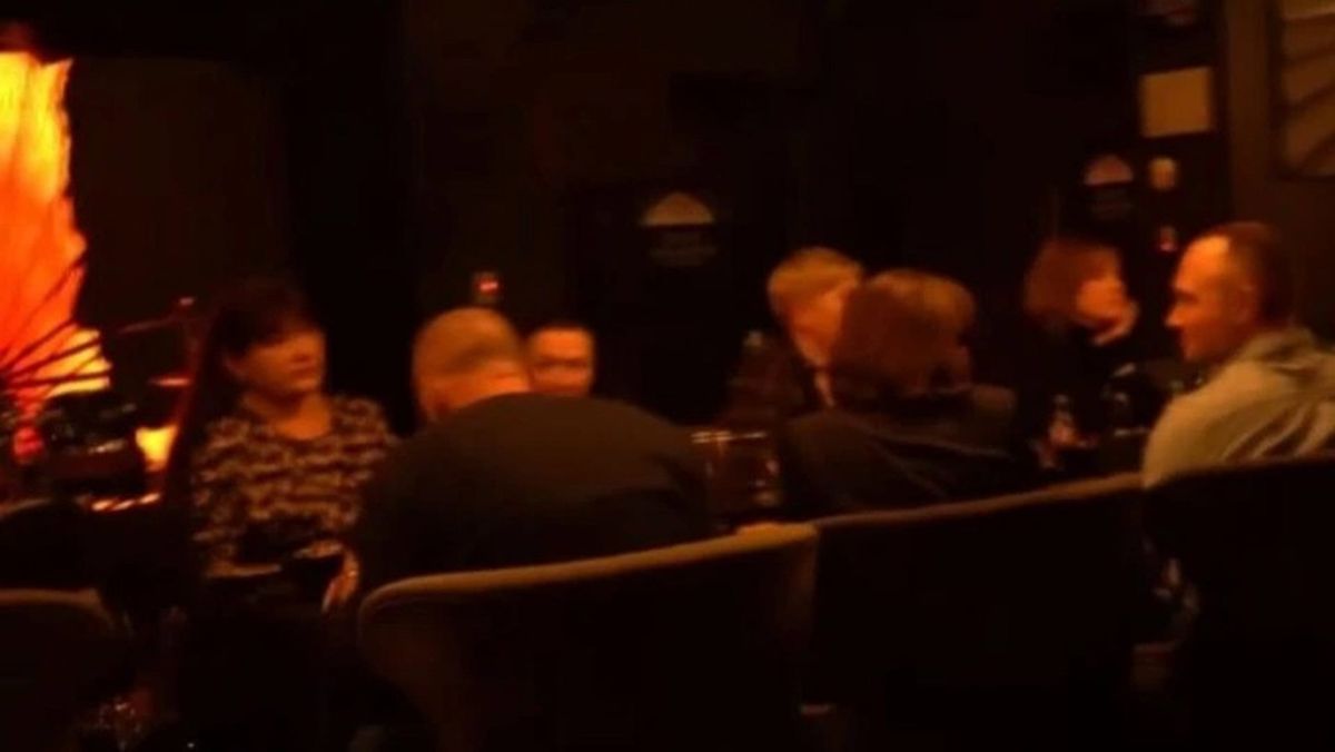 Клієнти ресторану сидять в темній залі