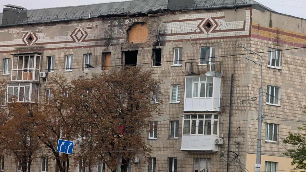 П’ятиповерховий житловий будинок із пошкодженим верхнім поверхом після обстрілу