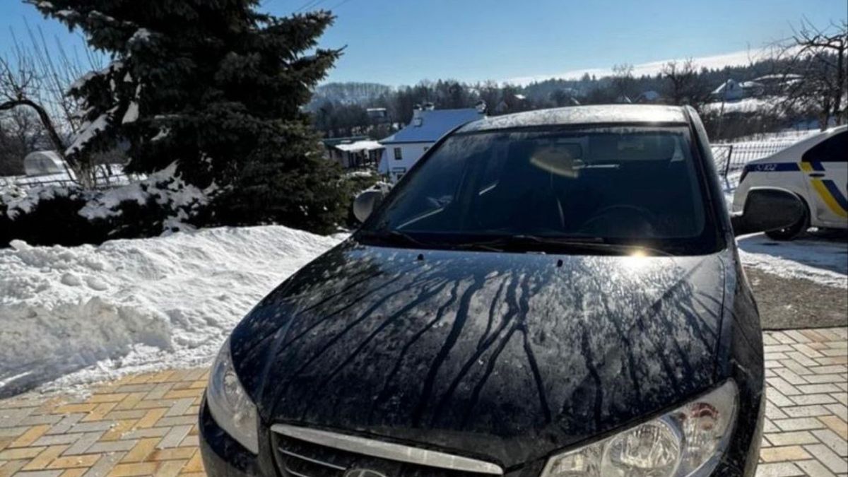 В Обухові затримали викрадача авто з АЗС Чорний автомобіль Hyundai Elantra на засніженому подвір'ї у селі Нещерів, на задньому плані видно поліцейський автомобіль