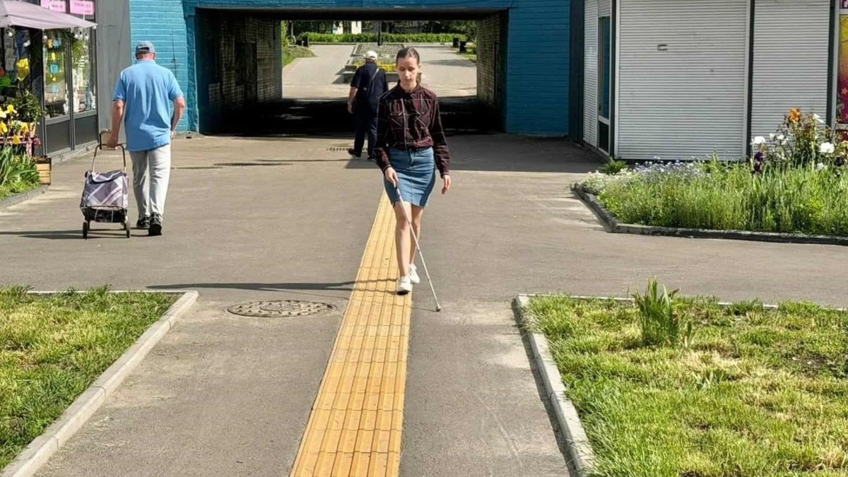 У Києві 2026 року облаштують 25 безбар'єрних підходів до соціальних об'єктів Молода жінка з тростиною орієнтується по жовтій тактильній плитці безбар'єрного пішохідного маршруту у Києві поблизу підземного переходу