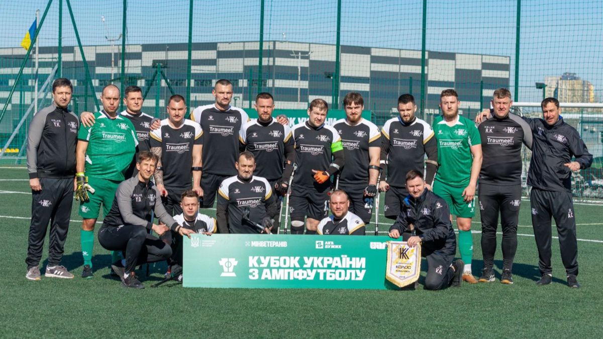 Гравці та тренерський штаб ФК «Колос-Буревій» з Київщини позують із банером «Кубок України з ампфутболу» на футбольному полі в Софіївській Борщагівці