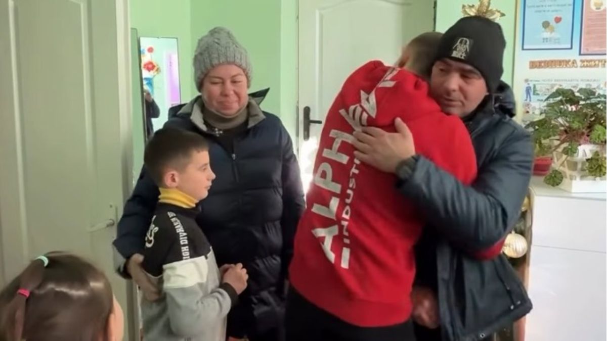 Батько обіймається зі старшим сином, лівіше – мати поряд з молодшим