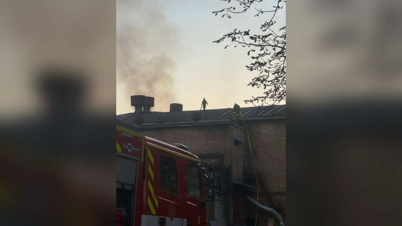 Головні новини Києва | Kyiv.News Рятувальники ДСНС на даху цегляного павільйону Кіностудії Довженка в Києві, поруч пожежна машина й дим