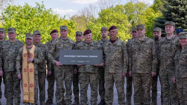 Військовослужбовці тримають меморіальну плиту із написом «Взаємодія, підтримка, пошана» на Алеї українського війська в Києві