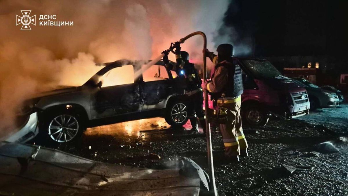 Пожежник гасить вогонь в машині