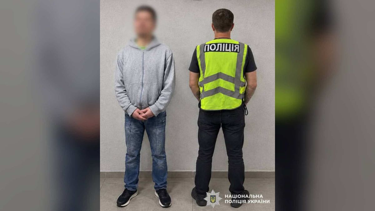 Поліцейський у жилеті «Поліція» поруч із 43-річним киянином, якого обвинувачують у крадіжках мобільних телефонів у Києві