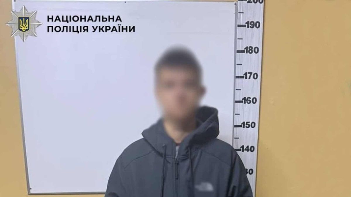Підозрюваний у шахрайстві 18-річний киянин із розмитим обличчям біля зростоміра на фото поліції Києва