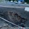 Головні новини Києва | Kyiv.News Вирва на проїжджій частині після ворожого влучання в Києві, місце огороджене стрічкою, працює патрульна поліція