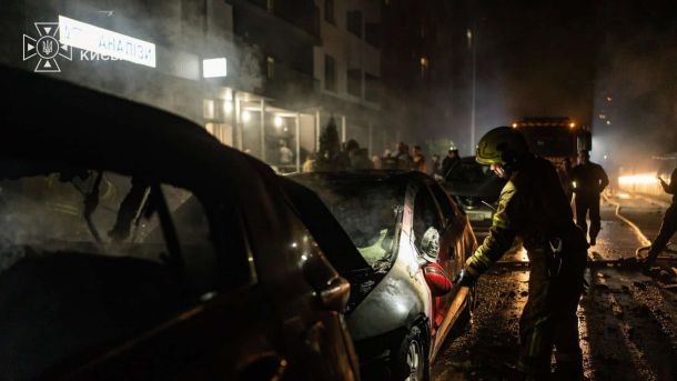 Рятувальник гасить згорілі автівки біля житлового будинку в Солом’янському р-ні Києва вночі 1 жовтня 2026 року