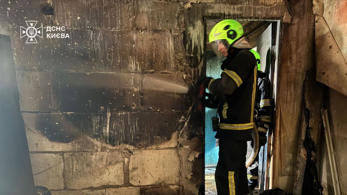 Рятувальник ДСНС Києва у спаленій квартирі на першому поверсі п'ятиповерхівки у Подільському районі після ліквідації пожежі