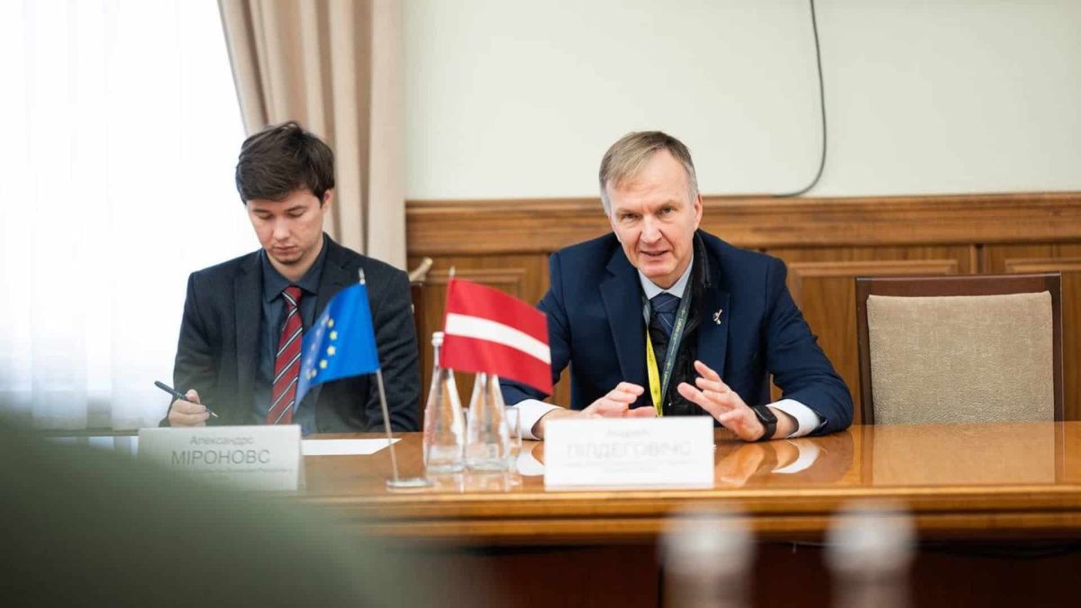 Двоє чоловіків сидять за столом у приміщенні під час офіційної зустрічі
