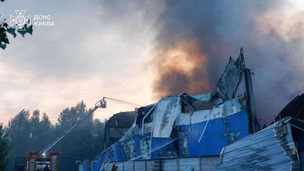 Рятувальники гасять пожежу складу з автодрабини, густий дим над будівлею, обстріл 8 липня